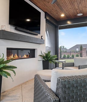 An outdoor living space with a fireplace and entertainment TV